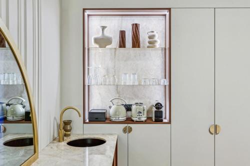 La salle de bains est pourvue d'un lavabo et d'une étagère avec de la vaisselle. dans l'établissement Modern apartment - 2P - Parc Monceau, à Paris