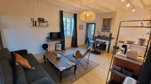 a living room with a couch and a table at 16 Bis-Gîte-Hôtel-Appartement in Marssac-sur-Tarn