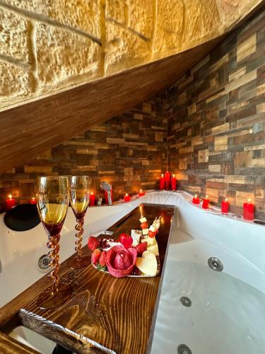 a bath tub with a tray of food and two glasses of wine at Rokwood faraya in Ash Sha‘rah