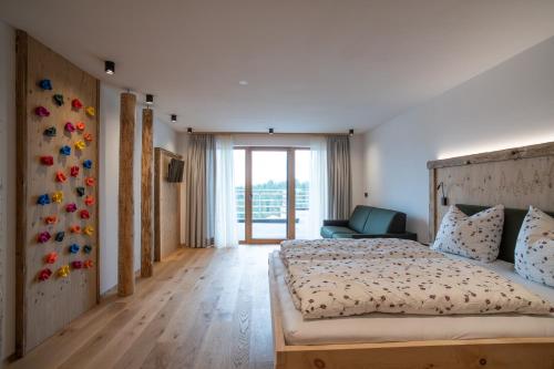 a bedroom with a large bed and a chair at Lanzenschuster in San Genesio Atesino