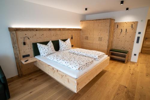 a bedroom with a bed with a wooden headboard at Lanzenschuster in San Genesio Atesino