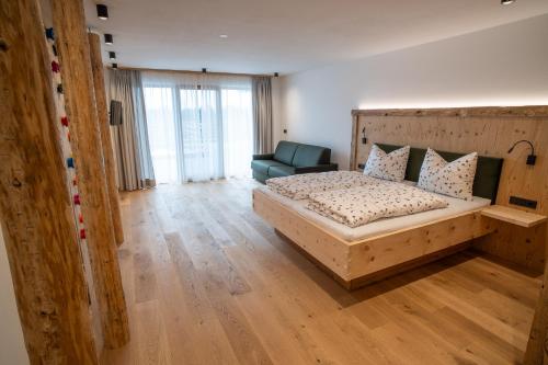 a bedroom with a large bed and a couch at Lanzenschuster in San Genesio Atesino