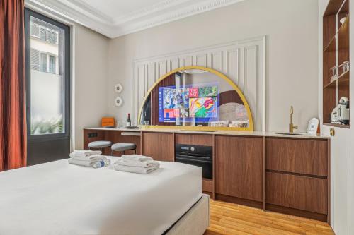 une cuisine avec une grande table blanche et un miroir dans l'établissement Modern apartment - 2P - Parc Monceau, à Paris
