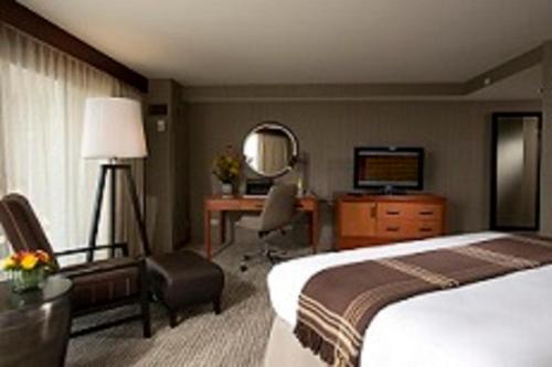 a hotel room with a bed and a desk and a television at Eaglewood Resort & Spa in Itasca