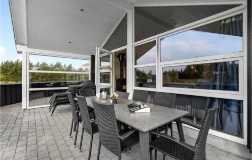 a patio with a table and chairs and windows at 3 Bedroom Amazing Home In Hemmet in Hemmet