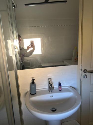 a man taking a picture of a sink in a bathroom at Gîte de la Fontaine Gorges de Daluis in Daluis