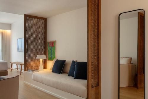 a living room with a couch and a mirror at Elisabeth by the Sea Hotel in Tossa de Mar