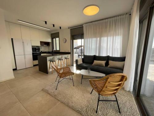 a living room with a couch and a table and chairs at luxury penthouse with a jaccuzi, pool and parking, suka for Sukkot optional in H̱olon