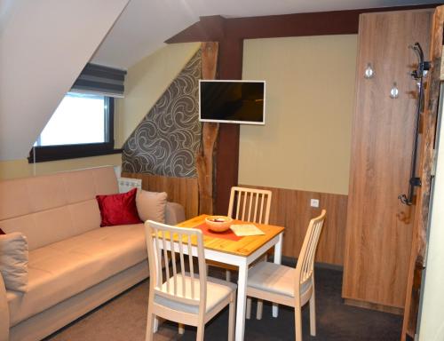 a living room with a couch and a table and chairs at SKI MONTIS apartmani - Kopaonik centar in Kopaonik