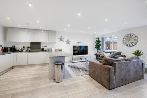 a living room with a couch and a kitchen at St Martins 2 Bedroom Apartments in Ruislip By 360 Stays in Ruislip