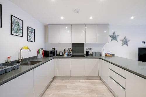 a kitchen with white cabinets and blue stars on the wall at St Martins 2 Bedroom Apartments in Ruislip By 360 Stays in Ruislip
