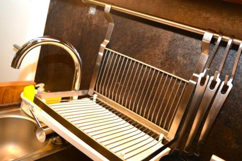 a metal drying rack next to a sink at SKI MONTIS apartmani - Kopaonik centar in Kopaonik