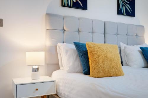 a bedroom with a large white bed with blue pillows at St Martins 2 Bedroom Apartments in Ruislip By 360 Stays in Ruislip