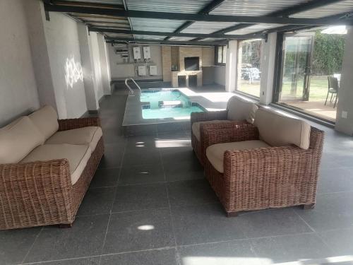 a living room with two couches and a swimming pool at Luyana guesthouse in Kroonstad
