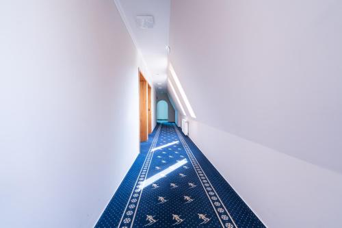 an aisle in a building with blue carpet at Hotel Ski&Sky in Predeal