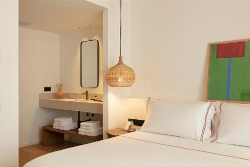 a bedroom with a white bed and a sink at Elisabeth by the Sea Hotel in Tossa de Mar