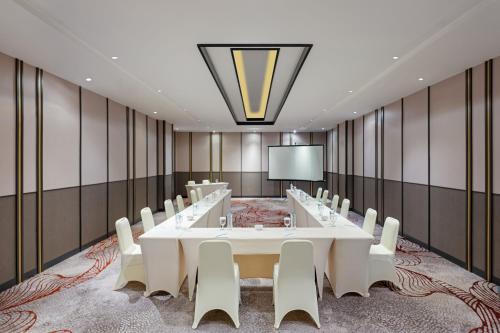 a conference room with a large white table and chairs at Hotel Santika Lahat in Lahat