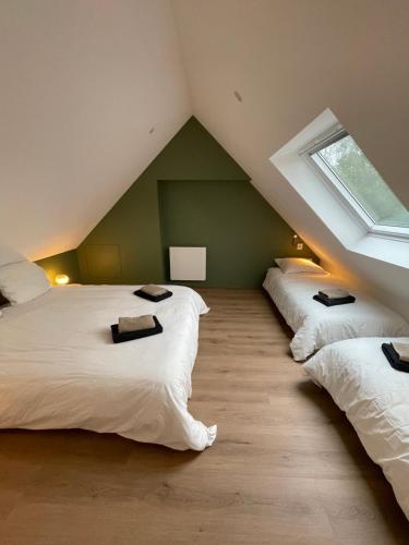- une chambre mansardée avec 3 lits et une fenêtre dans l'établissement Nouveauté Ty Cosquer Maison de vacances proche plages, à Fouesnant