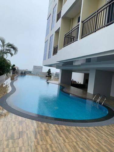 a large swimming pool in front of a building at Cozy Apartment 26TH with Seaview in Nagoya
