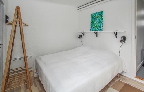 a bedroom with a white bed and a ladder at Fyrassistentens in Kolby Kås