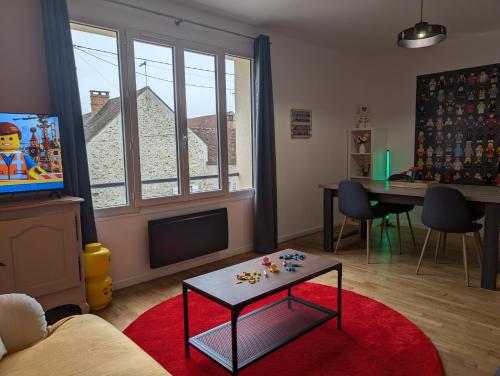 un salon avec une télévision et une table dans l'établissement Brick and Dream - 20min Disneyland - Familly - Parking, à Mortcerf