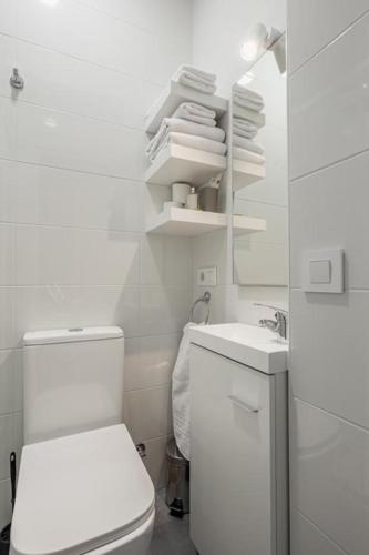 a white bathroom with a toilet and a sink at La Casona de Llovio próxima a Ribadesella in Llovio