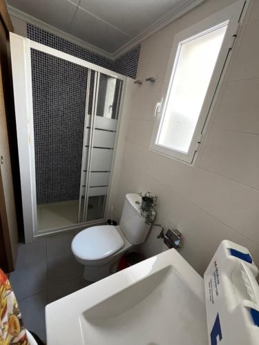 a white bathroom with a toilet and a sink at Piso a 3 minutos de la playa!! 6 personas in Cullera