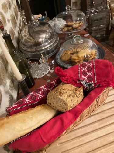 - une table avec un panier de pain et une bouteille de vin dans l'établissement Chambres d'hôtes Le Relais de la Perle, à Le Vernois