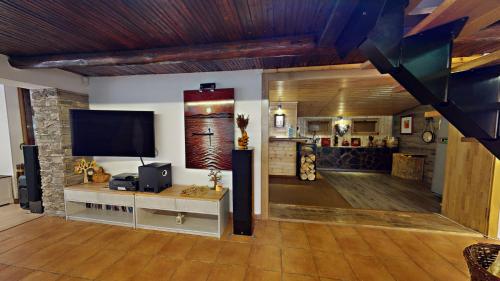 a living room with a flat screen tv on the wall at Chata v srdci lesa in Čadca