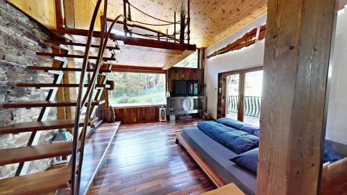 a living room with a couch and a spiral staircase at Chata v srdci lesa in Čadca
