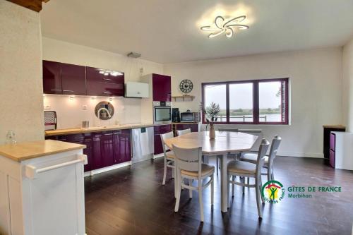 a kitchen with a table and chairs in a kitchen at Maison de la vilaine in Saint-Dolay