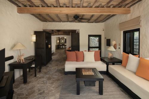 a living room with two couches and a table at Six Senses Zighy Bay in Dibba