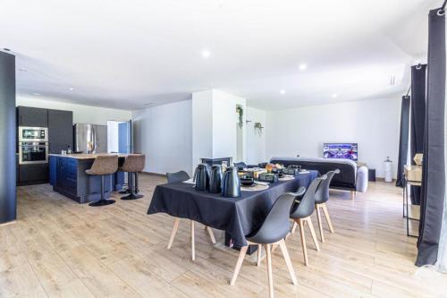 a room with a table and chairs and a kitchen at L'Ostau deu Bonur - chambres d'hôtes in Saint-Martin