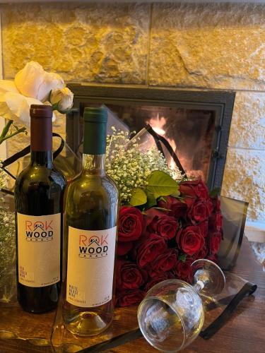 two bottles of wine next to a bouquet of roses at Rokwood faraya in Ash Sha‘rah