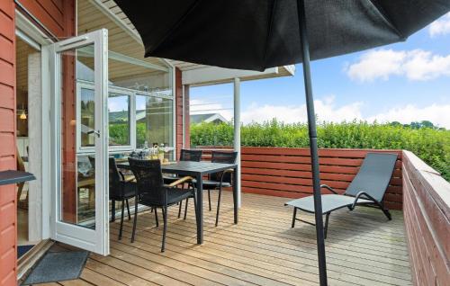 a patio with a table and chairs and an umbrella at 2 Bedroom Awesome Home In Tranekær in Tranekær