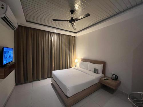 a bedroom with a bed and a ceiling fan at Hotel Hibiscus Tree- Bachupally in Hyderabad