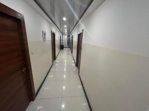 a long hallway with doors and a tile floor at Hotel Hibiscus Tree- Bachupally in Hyderabad