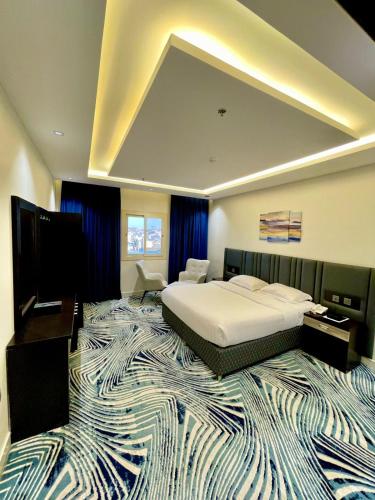 a bedroom with a large bed and a large rug at فندق قمم بارك Qimam Park Hotel 6 in Al Namas