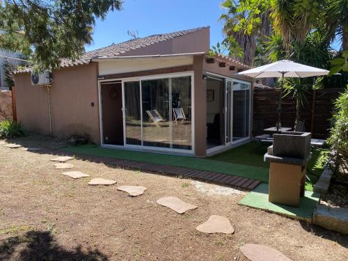 une maison avec un patio avec des rochers dans la cour dans l'établissement Mini villa SANTA GIULIA, à Porto-Vecchio