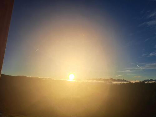 a sun setting in the sky above the horizon at Lanzenschuster in San Genesio Atesino
