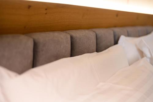 a close up of a bed with white sheets and pillows at Adore Home in Tirana