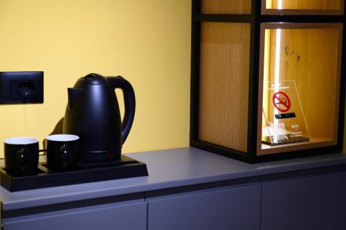 a tea kettle and two cups on a counter at Adore Home in Tirana