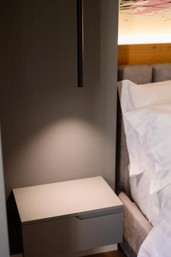 a white table next to a bed in a room at Adore Home in Tirana
