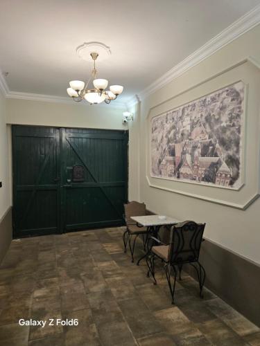 a room with a table and chairs and a painting on the wall at Face 1 Center SUBOTICA in Subotica