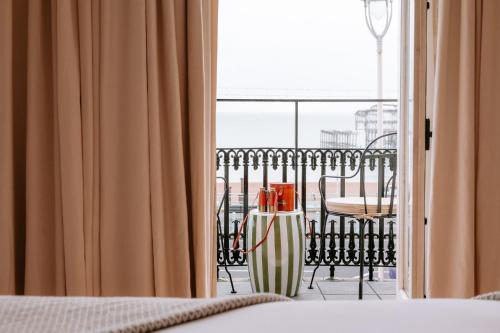 a room with a bed and a view of a balcony at No.124 by GuestHouse, Brighton in Brighton & Hove