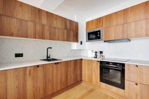 une cuisine avec des armoires en bois et un évier dans l'établissement Saint Michel - Notre Dame, à Paris