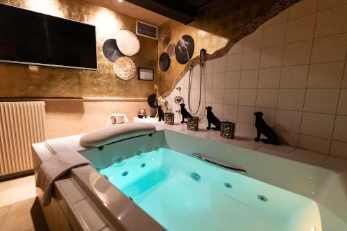 a bathroom with a tub with two cats sitting on a counter at Maiers Kuschelhotel Loipersdorf - ADULTS ONLY in Loipersdorf bei Fürstenfeld
