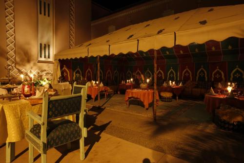 a large room with tables with candles on them at Hôtel Le Tinsouline in Zagora
