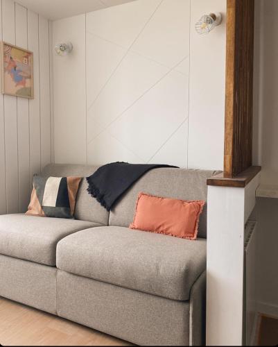 a couch with pillows on it in a room at BÈTH CÈU - 4 PERS - Appart vacances- in Arette
