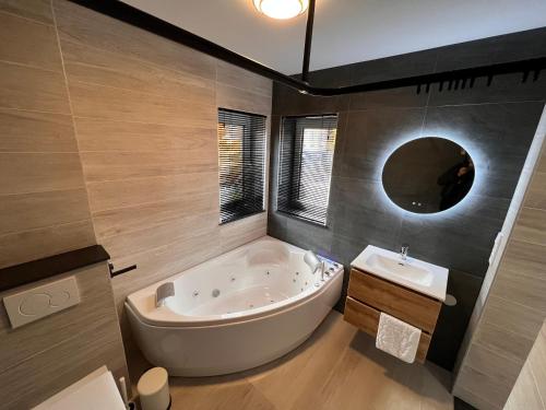 a bathroom with a large tub and a sink at Hotel Parkzicht in Valkenburg